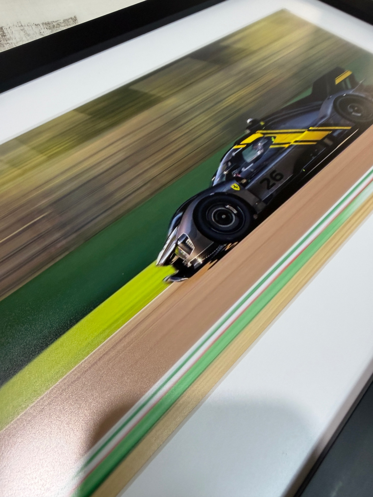 Close-up of a framed print of a racing car in motion