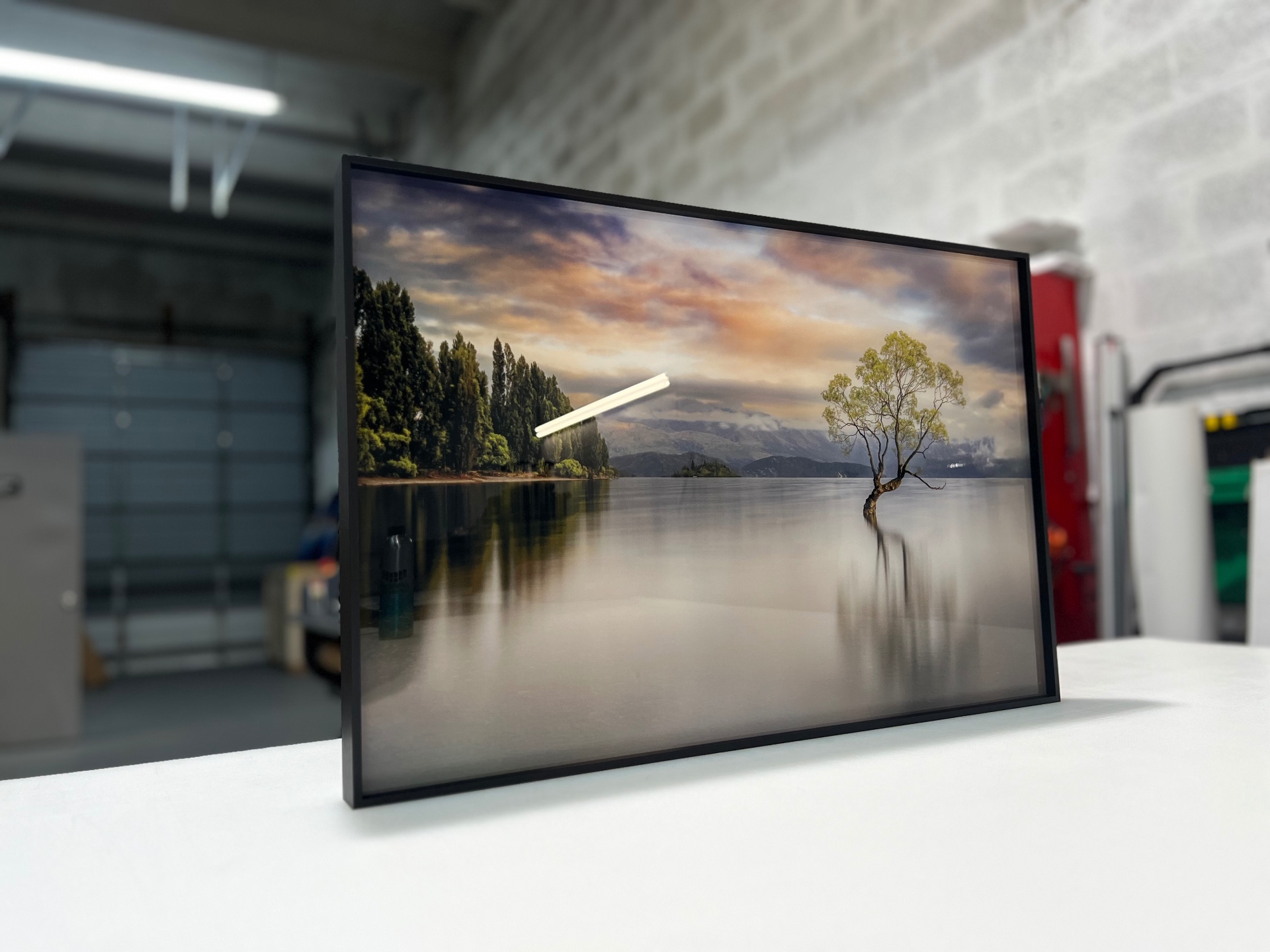 Landscape print of a lone tree in Lake Wanaka in a black float frame